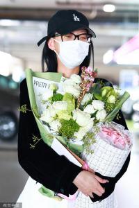 孫怡穿黑色外套搭白色短裙 手捧兩束鮮花笑眼彎彎